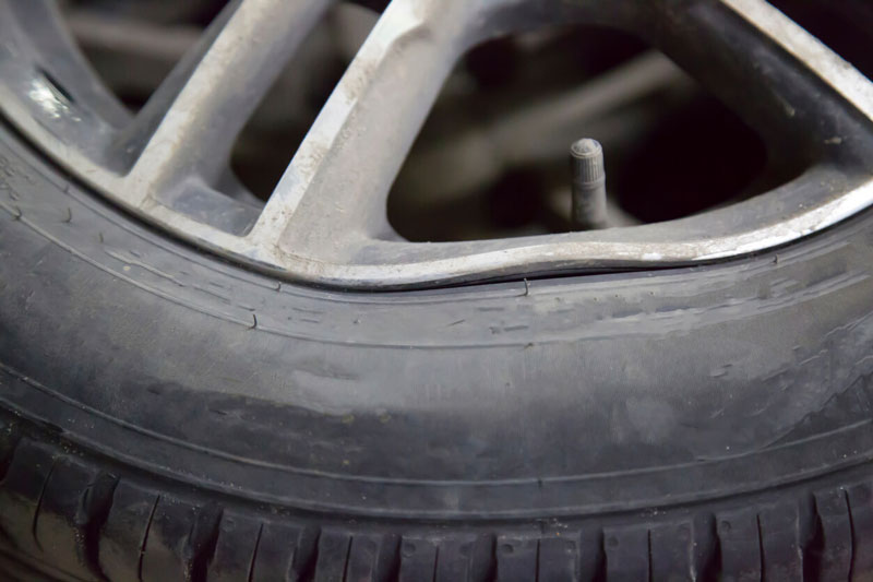 Alloy rim with buckled lip from hitting a curb or roadside debris with image showing repairable damage.